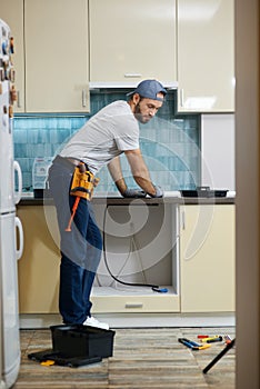 Full length shot of young repairman, professional plumber choosing the best tool for working. Tools and equipment on the