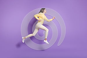 Full length side angle photo portrait of girl running jumping up isolated on vivid violet colored background