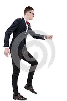 Full length side view of businessman climbing imaginary steps ag