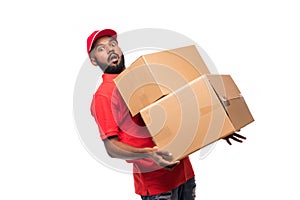 Full length side view of indian delivery man carrying cardboard box on white background