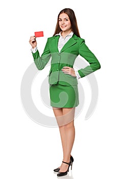 Full length of smiling business woman showing blank credit card in green suit, isolated over white background