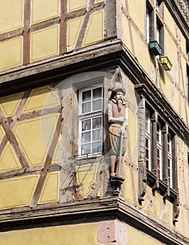 Full length statue of a man on the corner of a medieval building in Colmar, France