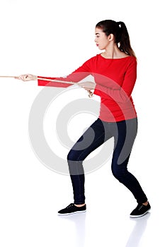 Full length strong woman puling rope
