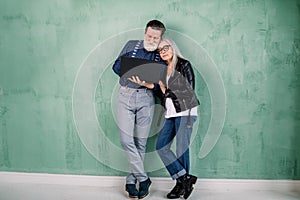 Full length studio portrait of attractive happy modern senior couple, man and woman, wearing trendy stylish clothes