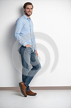 Full length studio portrait of casual young man in jeans and shirt. Isolated on white background.