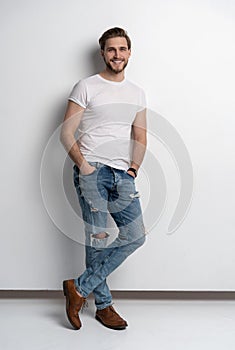 Full length studio portrait of casual young man in jeans and shirt. Isolated on white background.