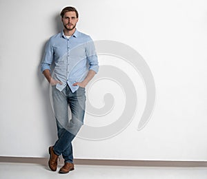 Full length studio portrait of casual young man in jeans and shirt. Isolated on white background.