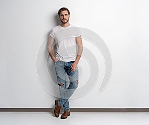 Full length studio portrait of casual young man in jeans and shirt. Isolated on white background.