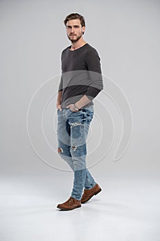 Full length studio portrait of casual young man in jeans and shirt. Isolated on white background.