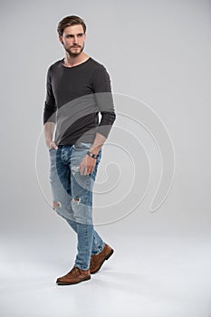 Full length studio portrait of casual young man in jeans and shirt. Isolated on white background.