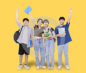 Full length of stylish teenager students on yellow background