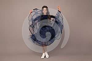 Full length of teenager child wearing ball dress. Movement dress of young child teen girl. Happy girl face, positive and