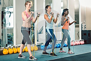 Full length of three fit women exercising with resistance bands