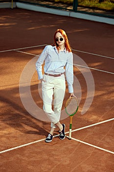 Full-length top view image of beautiful redhead young woman in stylish casual clothes and sunglasses posing on opendoor