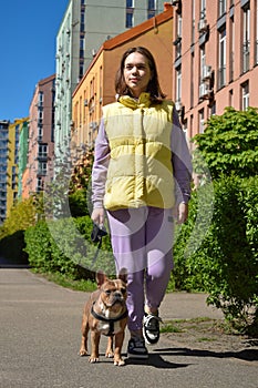 Full length townswoman walking a dog along city footpath outdoors photo