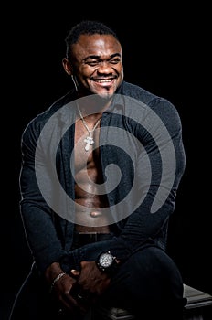 Full length view of the african american bodybuilder standing confidently on black studio background