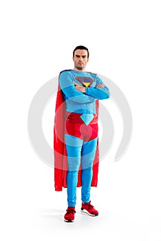 full length view of confident handsome superman standing with crossed arms and looking at camera photo