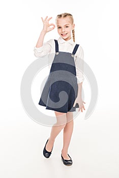 full length view of cute happy little girl showing ok sign