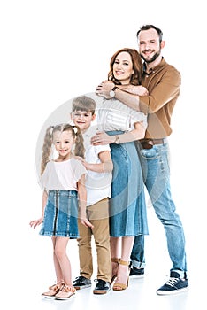 full length view of happy family with two children standing together and smiling at camera