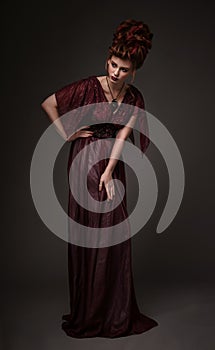 Full length view of woman with baroque hairstyle and evening maroon dress