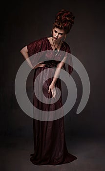 Full length view of woman with baroque hairstyle and evening maroon dress