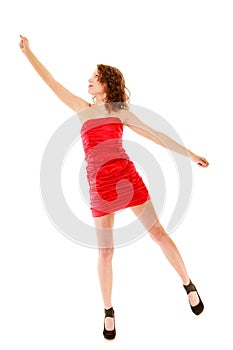 Full length woman in elegant red dress holding imaginary balloons and flying