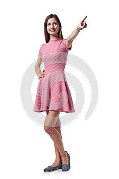 Full length woman in pink dress pointing to the side