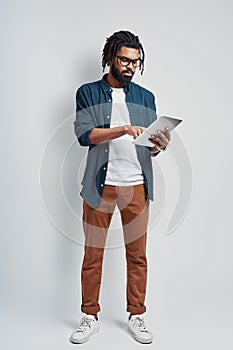 Full length of young African man in eyewear