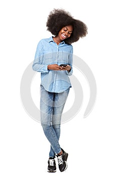 Full length young black woman smiling at mobile phone text message