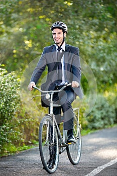 Full length of young businessman riding a bicycle