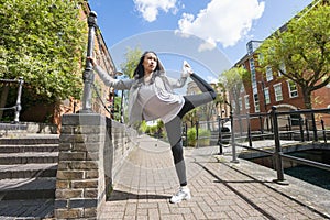 Full length of young fit woman exercising on sidewalk