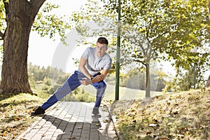 Full length of young man stretching on path in park