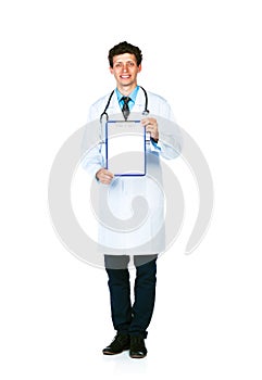 Full length young smiling male doctor showing clipboard with cop