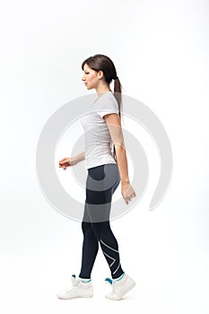Full length of a young woman walking over white background