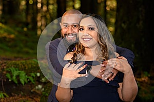 Full of love photo of an affectionate mixed race young couple holding each other in the woods