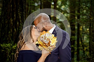 Full of love photo of an affectionate mixed race young couple kissing in the woods