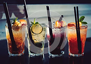 A full measure of bars. Cocktail drinks served in glasses with straws. Iced drinks in cocktail glasses. Alcoholic mixed