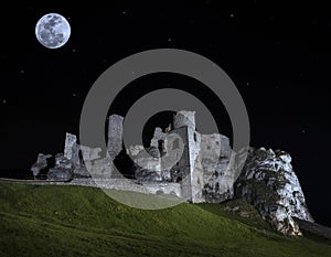 Full moon above ruins of castle.