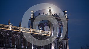 The full moon behind the ancient architecture in a city photo