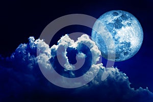 Full moon in blue lighting night sky background with clouds.