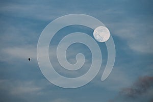 Full moon in blue sky with clouds