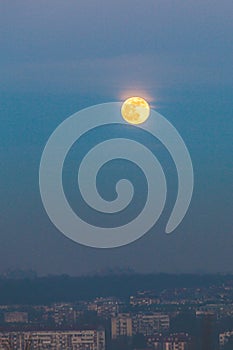 Full moon at dusk  above polluted city  of Belgrade