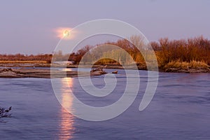 Full Moon on the Horizon Reflecting in the Platte River Water