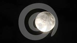 Full moon at night with cloud real time. 4k video full moon in the black sky.  Clouds passing by moon at night. night sky with clo