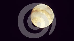 Full moon at night with cloud real time. 4k video full moon in the black sky.  Clouds passing by moon at night. night sky with clo