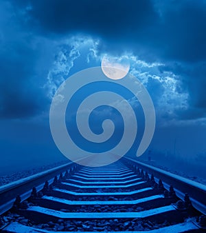 Full moon in night sky with clouds over railroad