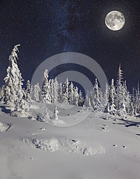 Full moon in night sky in winter mountains