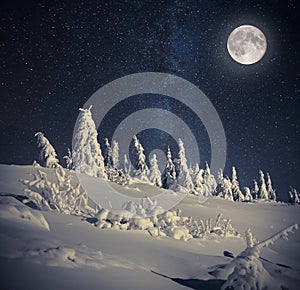 Full moon in night sky in winter mountains