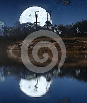 Full moon at the night time on sea with lunar reflection on the water.