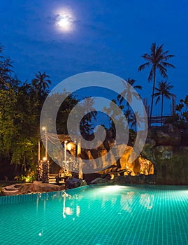 Full moon night view of a swimming pool on a beautiful resort at